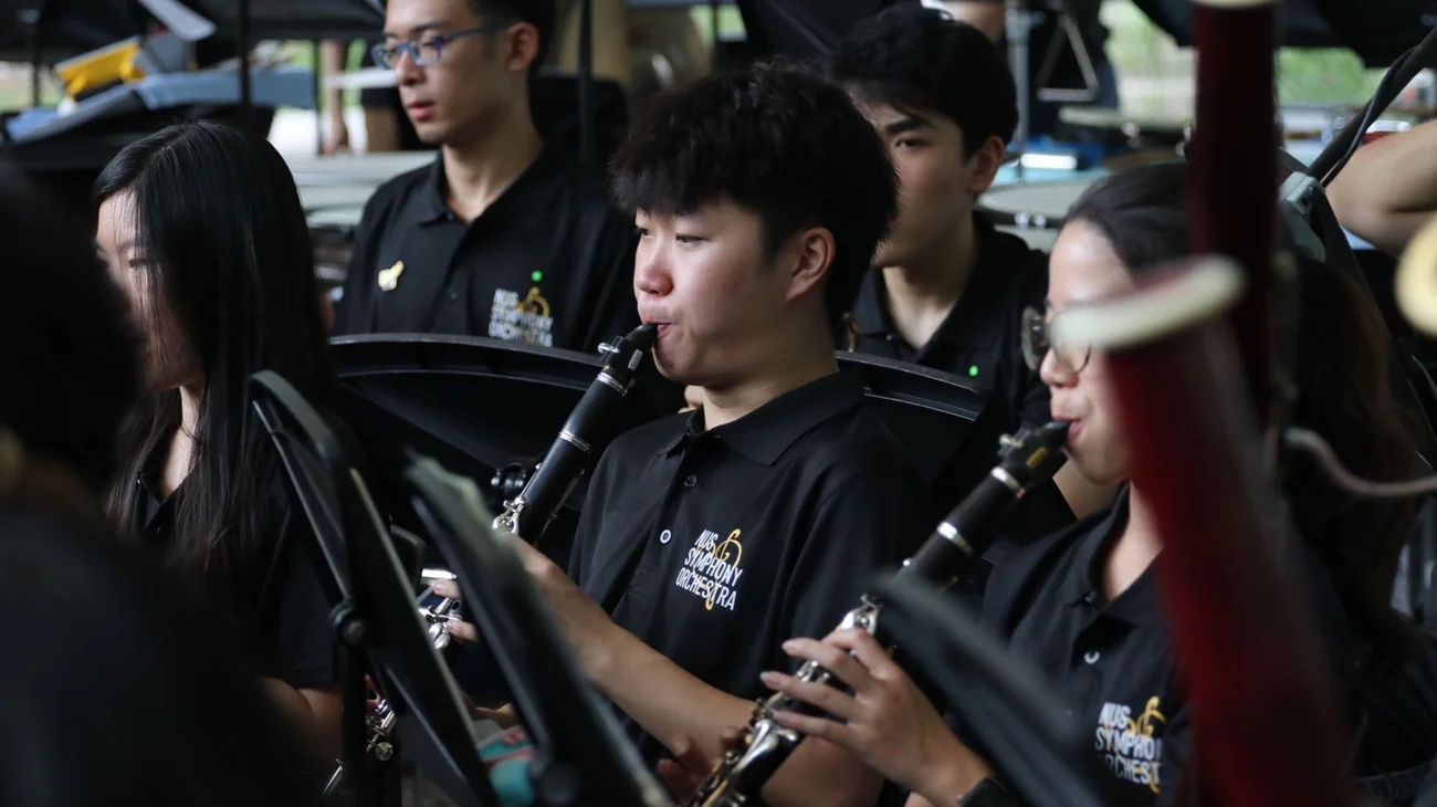 Zanwen playing clarinet at Singapore Botanic Gardens, seated among fellow woodwind players